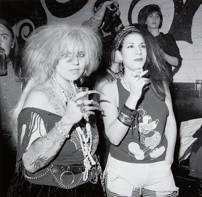 [2 women, one with clawlike finger coverings and one wearing Mickey Mouse shirt]