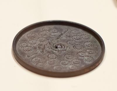 Round mirror with flying cranes surrounded by chrysanthemums